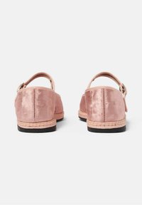 Zapatos de terciopelo rosa con punta redonda, correa trasera y detalles de yute trenzado alrededor de la suela, con una base plana de goma negra.