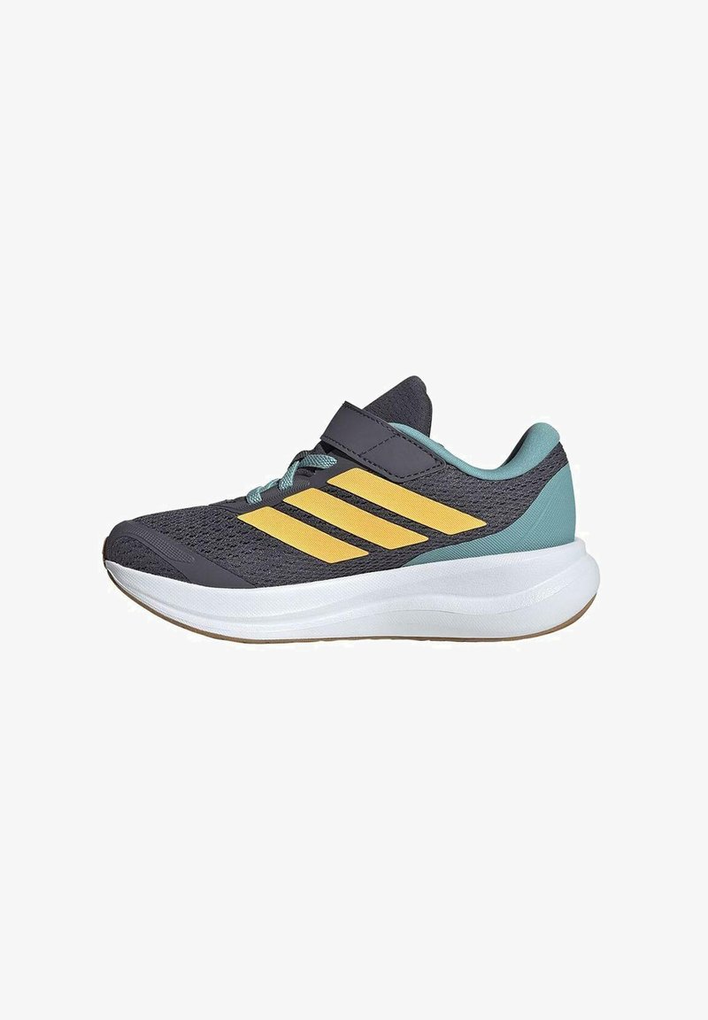 Chaussure de sport gris foncé et bleu sarcelle avec des rayures jaunes, une semelle blanche épaisse et une seule sangle noire en Velcro sur le dessus.