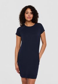 Granatowa sukienka z krótkim rękawem z miękkiego materiału o luźnym kroju, z bocznymi kieszeniami i okrągłym dekoltem. Szwy na rękawach.