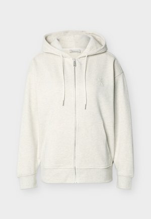 Φωτεινή μπεζ φούτερ με φερμουάρ, κουκούλα με κορδόνι, τσέπες μπροστά και διακριτικό κεντημένο λογότυπο στο αριστερό στήθος.