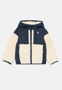 Giacca con cappuccio blu navy con pannelli in pelliccia sintetica crema, chiusura frontale con zip, due tasche sul petto e un'etichetta con logo sul lato sinistro.