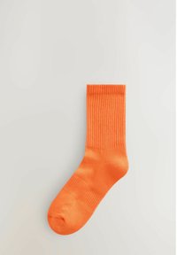 Oranžid puuvillased sokid ribaga mansetiga ja siledast tekstuurist, tavalise meeskonna pikkusega ja ümarate varvastega.
