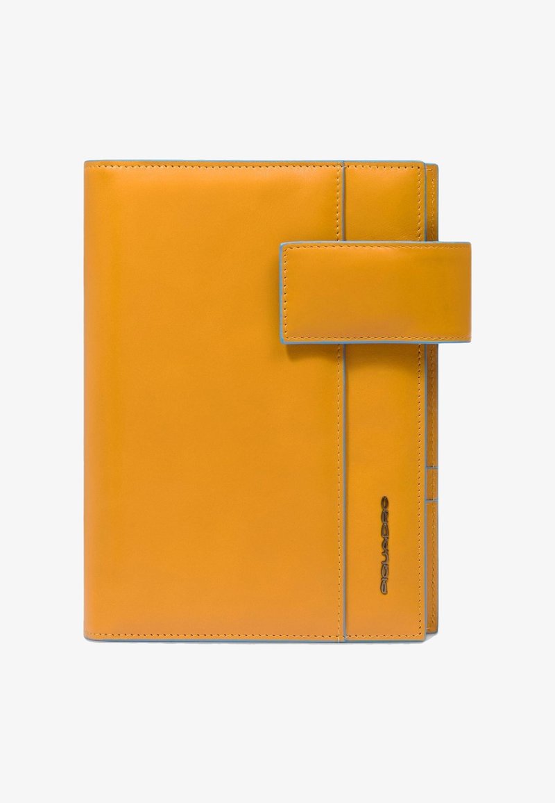 Gele leren notitieboekhoes met blauwe accentstiksels en een klepsluiting. Heeft een logo dat in het leer is gedrukt aan de zijkant. Gladde textuur.