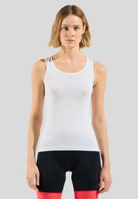 Witte sportieve tanktop met een gewatteerd meshontwerp, voorzien van een ronde halslijn en smalle banden, gecombineerd met zwart-rode fietsbroekjes.
