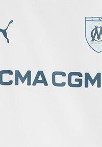 Vit sporttröja med en blå Puma-logotyp, texten "CMA CGM" i fet stil i blå bokstäver och en blå och vit emblem för Marseille-klubben.