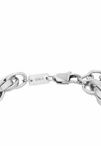 Pulsera de acero inoxidable con eslabones entrelazados, acabado cepillado y cierre de presión. Presenta una etiqueta grabada que dice "STEEL."