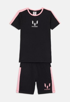 Sort kortærmet skjorte og shorts med pink striber og Messi-logo på brystet og venstre ben, mod en hvid baggrund.