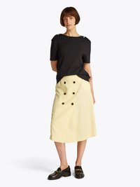 Black short-sleeve top with shoulder buttons, paired with a light yellow mid-length skirt featuring a double-breasted design and black buttons.