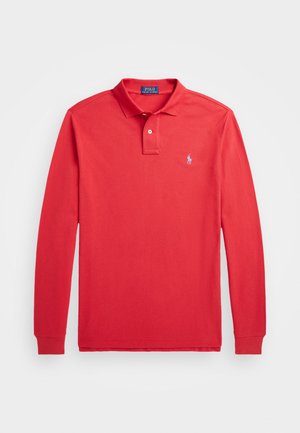 Polo de manga larga rojo con un cuello plegado, tapeta de dos botones y un pequeño logo azul en el lado izquierdo del pecho. Tela de algodón suave.