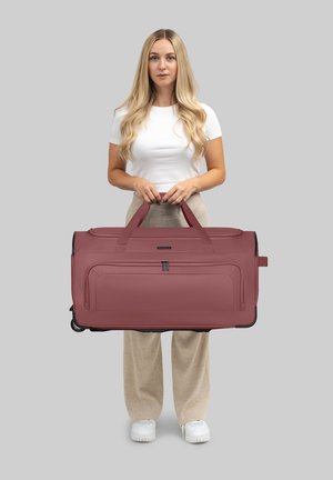 Grande borsa da viaggio marrone bordeaux con maniglie doppie, tasche con zip, superficie texture e base con ruote per un facile trasporto.