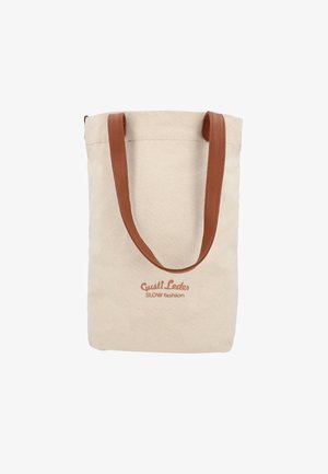 Beige lærredsnet med brune læderhåndtag og "Gusti Leder SLOW fashion" logo trykt på fronten.