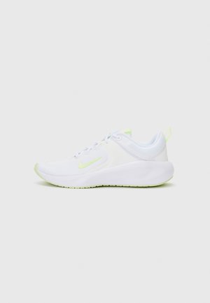 Zapatilla deportiva blanca con detalles en verde claro, suela acolchada, diseño con cordones y logo Nike swoosh en el lateral.