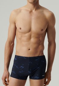 Szorty kąpielowe w kolorze granatowym z abstrakcyjnymi ciemnoniebieskimi zawijasami, wykonane z elastycznego materiału, charakteryzujące się dopasowanym krojem i logotypem marki z boku.