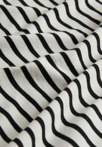 Weicher Stoff mit schwarz-weißen horizontalen Streifen, die leichte Falten und Texturdetails zeigen.