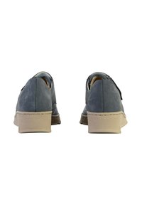 Une paire de chaussures casual bleues avec des semelles texturées beiges, vue de l'arrière sur un fond blanc.