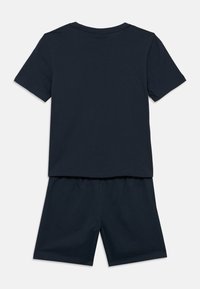 Tamsiai mėlynas medvilninis marškinėlių ir šortų rinkinys, su trumpomis rankovėmis, apvaliu kaklu ir elastinga juosmens juosta šortuose.