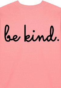Rózsaszín pulóver, amelynek hátulján hangsúlyos, fekete, hajlékony betűkkel a "legyél kedves" felirat található. Az anyag puhának tűnik, bordázott nyakkivágással.