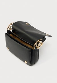 Μαύρη δερμάτινη τσάντα χειρός με υφή στην επιφάνεια, χρυσές μεταλλικές λεπτομέρειες, ανοιχτό επάνω μέρος και εσωτερικό με δύο διαμερίσματα.