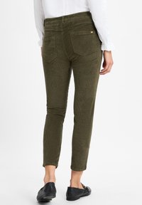Olijf groene corduroy broek met een slim fit, gekenmerkt door een hoge tailleband, twee achterzakken en een cropped pijp die boven de enkel eindigt.
