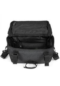 Borsa rettangolare nera con una superficie Texturizzata, parte superiore con zip e spallacci regolabili. L'interno è foderato con tessuto nero e presenta una tasca.