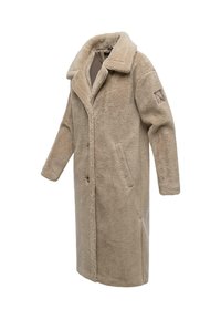 Beige schapenleren jas met brede kraag, lange mouwen, knopen aan de voorkant en twee zijzakken. Heeft een gestructureerde stof en een patch op de arm.