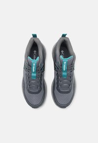 Ténis desportivos cinzentos com parte superior em malha, detalhes em teal na língua e interior, e uma sola de borracha texturizada. Cadarços na cor cinza correspondente.