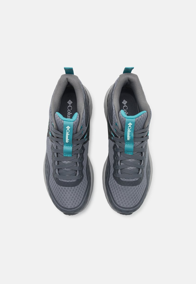 Graue Sportschuhe mit einem Mesh-Obermaterial, türkisfarbenen Akzenten auf der Zunge und im Innenbereich sowie einer strukturierten Gummisohle. Schnürsenkel in passendem Grauton.