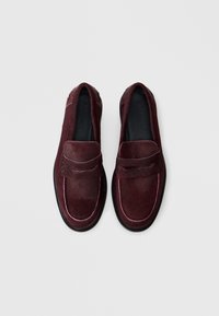Bordeaux loafers van textiel met roze stiksel, ronde neus, en lage zwarte zool. Het ontwerp heeft een decoratieve voorband.