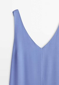Haut sans manches bleu clair avec un profond décolleté en V, fabriqué dans un tissu doux et lisse.