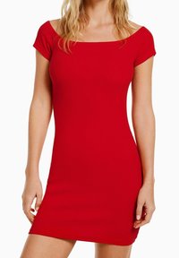Robe rouge à côtes avec un décolleté carré et des manches courtes, présentant une coupe ajustée qui arrive à mi-cuisse. Texture lisse sans motifs.