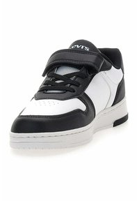 Scarpa da ginnastica in bianco e nero con tomaia in pelle sintetica, dotata di cinturino in Velcro, chiusura con lacci e accenti in mesh testurizzato sulla linguetta.