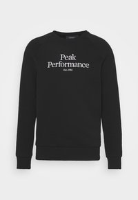 Sudadera negra con escote de crew y mangas raglán. Presenta "Peak Performance" y "Est. 1986" impresos en blanco en la parte delantera.