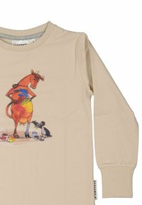 Beige pitkähihaine paita, jossa on värikäs sarjakuvakuvitus lehmästä ja linnusta, eloisilla maalitahrilla ja leikkisillä yksityiskohdilla.