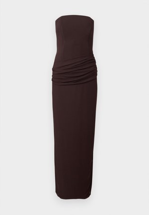 Vállpánt nélküli, sötétbarna, testhez simuló estélyi ruha, mely deréktájon ráncolt részlettel és egyenes, hosszú szoknyával rendelkezik.