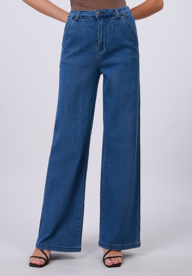 Jeans blu a gamba larga realizzati in denim, con vita alta, tasche frontali e chiusura con bottone. Texture liscia con dettagli sottili.