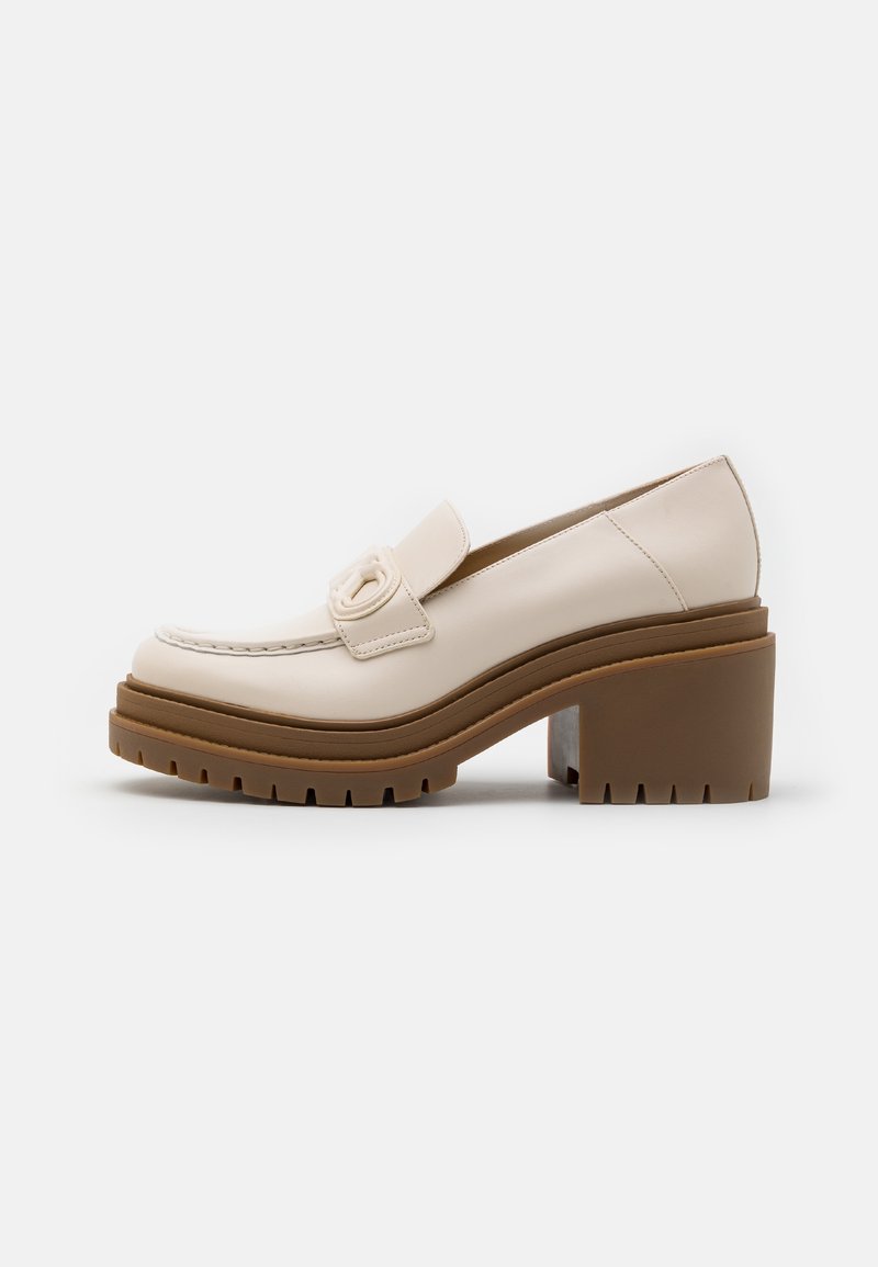 Beige läder loafers med en sytt tå, chunky brun platformssula och ett dekorativt band med en metallisk detalj.