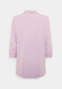 Blazer lilas à la coupe ajustée, doté d'un col cranté et de manches trois-quarts. Texture lisse avec des détails piqués sur les manches.