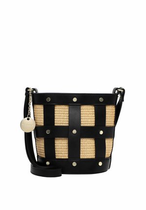 Sac seau avec corps en tissu beige tissé, bretelles en cuir noir croisant le devant, clous dorés, bandoulière réglable et pendentif rond en or avec le logo de la marque.