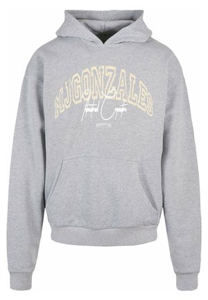 Grå hettegenser med frontlomme, med trykt hvit og beige tekst over brystet. Ribbestrikkede mansjetter og hem. Myk tekstur.