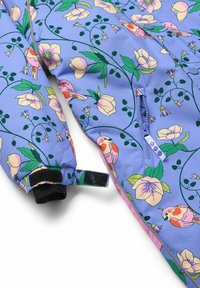 Chaqueta colorida y ligera que presenta un patrón floral azul con aves. Incluye un bolsillo con cremallera y puños de velcro. Acentos florales y de aves.