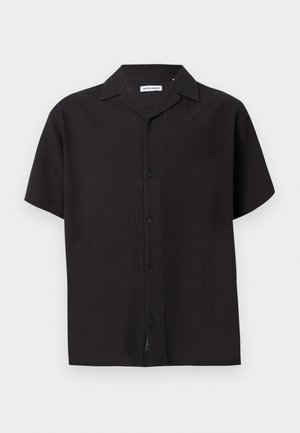 Chemise noire à manches courtes avec boutons, col pointu et étiquette de marque visible à l'intérieur du col.