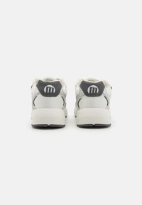 Sneakers bianchi con accenti grigi, materiali in rete e sintetici, colletto imbottito e dettaglio del logo sul tallone. Punta arrotondata e suola texturizzata.
