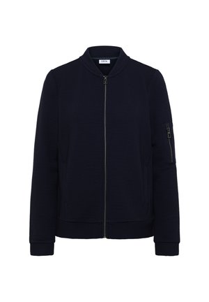 Veste bomber bleu marine avec texture côtelée, fermeture éclair sur le devant et poches latérales. Comprend une poche zippée sur la manche et un col rond.