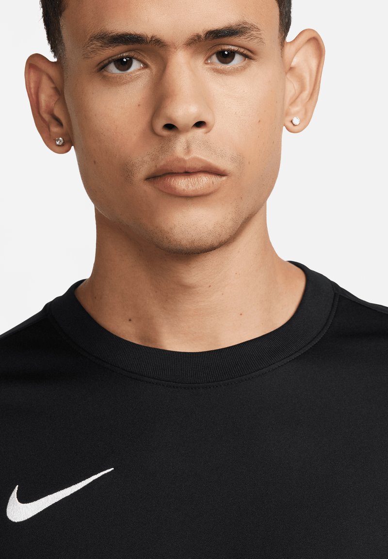 Zwarte Nike sweatshirt met een ronde hals, ribbelkraag en een wit logo op de borst, wat het minimalistische ontwerp benadrukt.