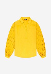 Blusa gialla a maniche lunghe con colletto. Corpo liscio, maniche trasparenti con motivo testurizzato e una sottile placca con bottoni sul davanti.