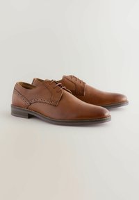 Chaussures de ville en cuir marron avec une finition lisse, des accents texturés sur les côtés et des lacets assortis. Présente un bout rond et un talon bas.