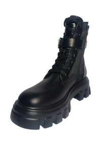 Bottine en cuir noir avec une semelle épaisse, fermeture à lacets à l'avant et une sangle ajustable autour de la cheville. Finition lisse et design robuste.