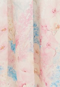 Μαλακό ροζ και μπλε λουλουδάτο μοτίβο σε διαφανές ύφασμα με λεπτά ανθάκια και φύλλα που δημιουργούν μια ελαφριά, αέρινη υφή.