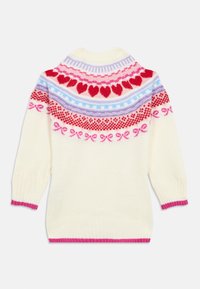 Vuneni džemper, kremasta podloga s šarenim pletenim uzorkom srca i mašni u crvenoj, ružičastoj i plavoj boji. Rebrasti rubovi i rub na dnu u ružičastoj boji.