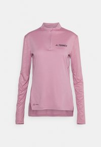 Maglietta sportiva a manica lunga di colore rosa chiaro con colletto a mezza zip, tessuto strutturato e logo 'TERREX' sul petto. Venti laterali per una maggiore mobilità.